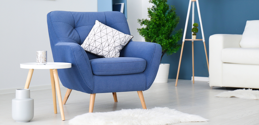 Fauteuil scandinave bleu avec pied en bois, coussin à motifs, table basse scandinave et vase 