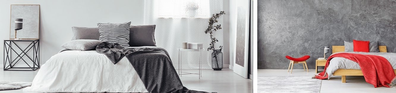 lit avec drap blanc, couverture grise, coussins gris, petite table metal, plante et lit couette grise couverture rouge oreillers gris et rouge, table bois, mini fauteuil rouge et bois murs gris