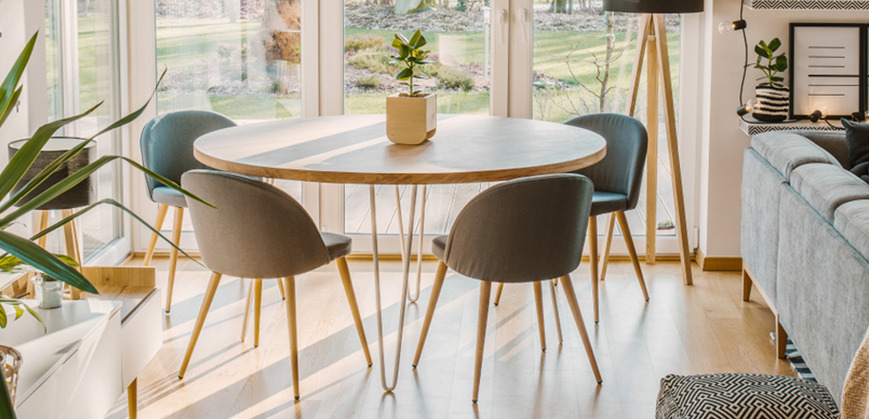 Salle à manger scandinave avec table ronde en bois et chaises scandinaves grises