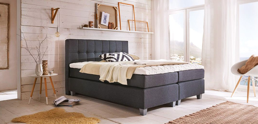 Lit Boxspring gris avec tête de lit, drap, table d'appoint et chaise style scandinave