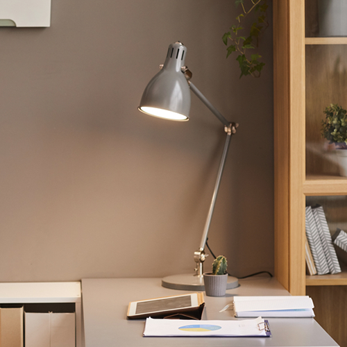 Lampe de bureau grise amovible sur table blanche